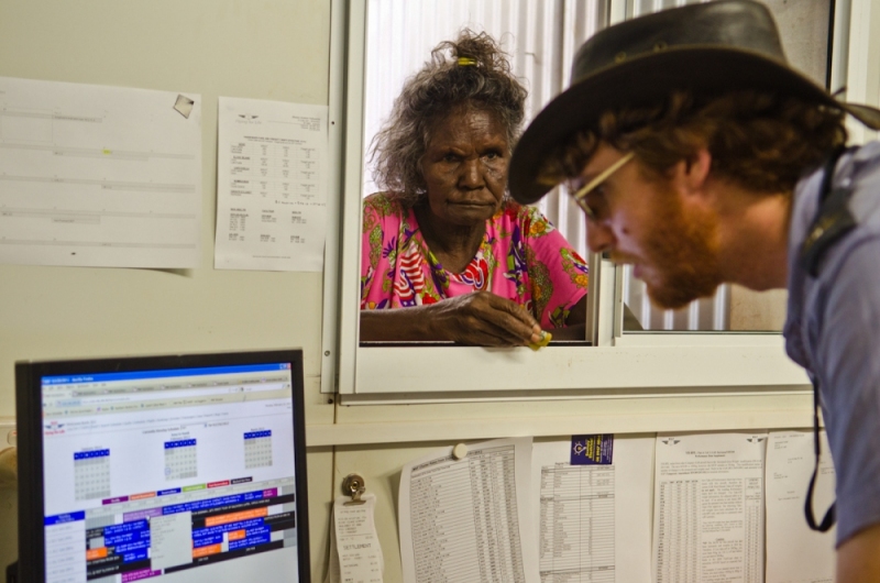 Pilot Ian Purdey helps a woman with a plane reservation at Elcho Island.