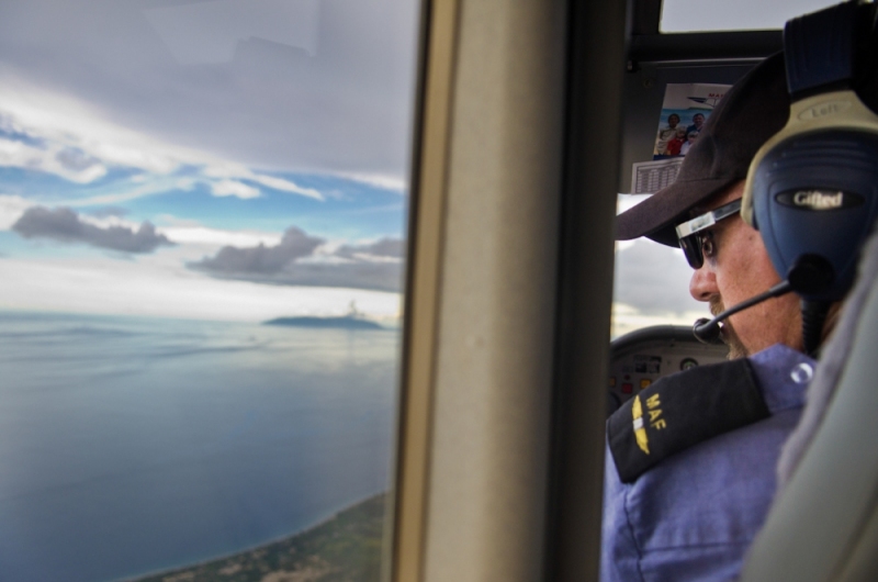 MAF pilot John Lowe  flies home over the ocean in East Timor.