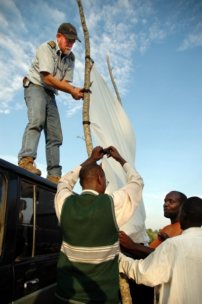 Jon Cadd, MAF pilot in Bunia, DR Congo, helps a local church set up an outdoor screen for showing a Christian movie.