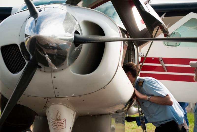 MAF pilot Joey Lincoln checks the engine on a pre-flight check.