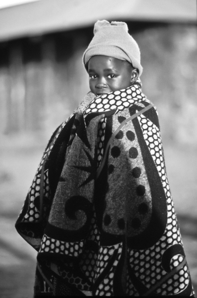 A Lesotho boy wraps himself in thick wool blanket, the standard "coat" in Lesotho.
