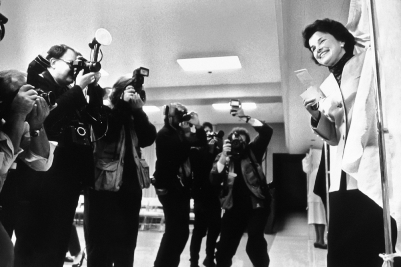 The mayor of San Francisco, Dianne Feinstein, comes out of the voting booth to a line of photojournalists in the election where she won a seat in the US Senate.