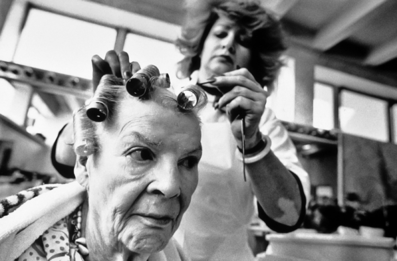 A resident of a long-term care facility in San Francisco has her hair done at the salon on the campus.